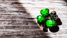 Brooch In The Form Of An Emerald Clover. St.Patrick 's Day. Wood Background.