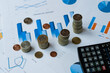 © yana_novak22 - Concept of financial economic data growth -- office supplies such as coins and abacus placed on financial data statements