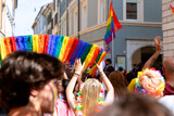 Fototapeta Tęcza - Young people hold a rainbow made of paper at a gay parade (LGBT Pride)