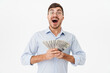 © Drobot Dean - Photo of delighted man holding dollars and expressing surprise