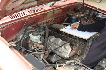 The mechanic is checking the engine.