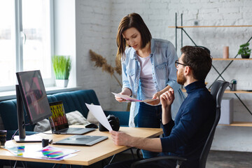 Photographer and graphic designer working in office with laptop, monitor, graphic drawing tablet and color palette. Creating team discussing ideas in advertising agency. Retouching images. Teamwork.