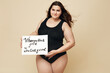 Plus Size Model. Full-figured Woman Portrait. Female Holding Motivational Poster With Inspiration Quote Written On Paper. Body Positive Brunette Looking At Camera.