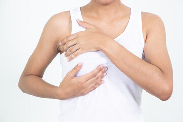 Woman hand checking lumps on her breast for signs of breast cancer on gray background. Healthcare concept.