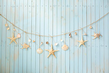 Blue Wooden Wall With A Garland From Sea Shells