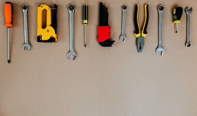 Wall Mural - Tools top view on craft paper. Plier, open wrenches, screwdrivers and staple gun flat lay with copy space.