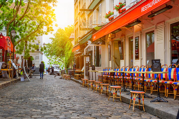 Wall Mural - Cozy street with tables of cafe in quarter Montmartre in Paris, France