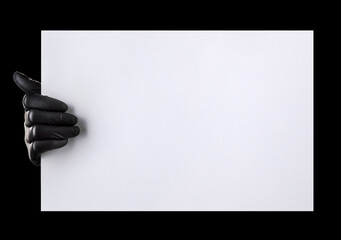 Wall Mural - Hand in black gloves holding blank cardboard isolated on black