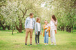 © travnikovstudio - Adorable family in blooming cherry garden on beautiful spring day