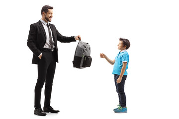 Wall Mural - Full length shot of a father giving a backpack to his son