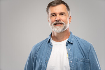 Wall Mural - Portrait of smiling mature man standing on white background.