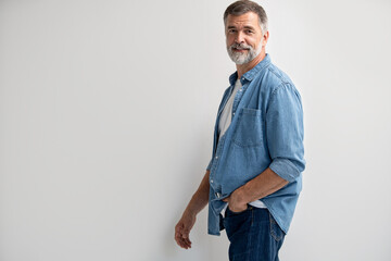 Wall Mural - Portrait of smiling mature man standing on white background.