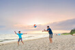 © romylee - Father and son playing with a ball on the beach