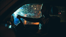 The Young Man Drives The Car On The Night Rainy Road
