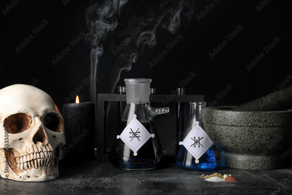 Potions, human skull, mortar and pestle on alchemist's table