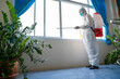 © visoot - Concept good hygienic care in the house,Man in hazmat PPE protective clothing wearing protective mask to Protect Against Covid-19 are cleaning and kill germs in the house.
