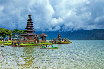 Wall Mural - Bratan Lake, Bali - November 25th, 2017: Tourist taking a cannoe trip to get closer view of Ulun Danu Bratan tample. The temple complex is located on the shores of Lake Bratan 