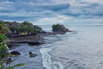 Wall Mural - Great landscape view of the wave from the sea hitting hard the beach with Tanah Lot main Temple as the background