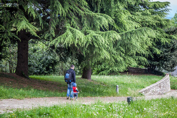 Wall Mural - A father and son walk along a path in San Vigilio Park. Bergamo. Lombardy. Italy