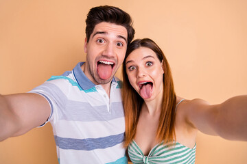 Wall Mural - Self-portrait of his he her she nice attractive lovely crazy overjoyed naughty playful cheerful cheery couple fooling grimacing having fun isolated over beige pastel color background