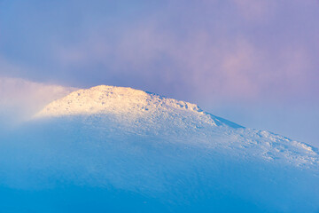 Wall Mural - snow capped mountain peak disappears into the clouds creating a beautiful painterly view of unspoile