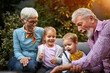 © luckybusiness - Grandfather entertains grandchildren