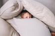 © Elena Kratovich - Little boy playing and hiding in pillows at home
