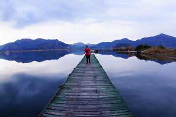 a young man on the wooden pier at the lake.