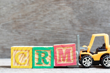 Canvas Print - Toy forklift hold letter block M to complete word CRM (Abbreviation of Customer Relationship Management) on wood background