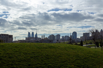  Overview of a city with tall buildings from a green park on a summer