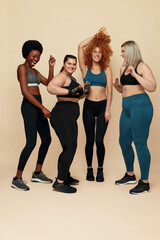 Women. Group Of Diversity Models Of Different Ethnicity Portrait. Group Of Multi-Ethnic Female Friends In Sportswear Posing On Beige Background. Body Positive As Lifestyle.