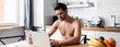 © LIGHTFIELD STUDIOS - sexy shirtless freelancer working on laptop on kitchen with fruits and coffee, website header
