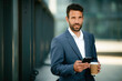© JustLife - Portrait of handsome businessman. Man using phone.