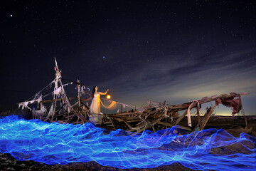 Wall Mural - Lady Light Painted on a Ghost Ship With Star Trails on Beach