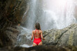 © Volodymyr_sh - Beautiful young slim blonde woman with curly hair, wearing in red swimsuit is enjoy in lagoon of huge tropical waterfall in jungle. Travel concept. Sexy woman wearing red swimsuit in the jungle.