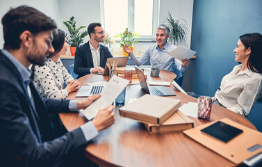 Wall Mural - Young managers discussing financial report with boss in office