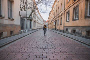 Wall Mural - Young woman walking on European street