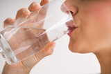 Fototapeta Łazienka - Thirsty Woman Drinking Water From Glass