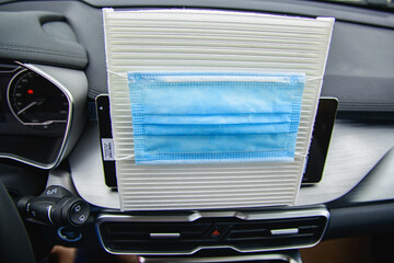 Wall Mural - car air conditioner air filter and a protective mask against bacteria on it