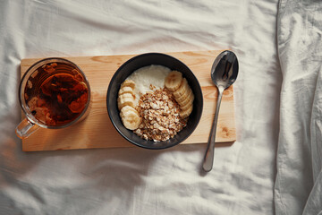 Wall Mural - Good morning. Breakfast in bed. Bowl of granola and cup of hot tea.