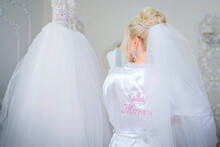 Attractive Bride Touches Her Wedding Dress. The Inscription On The Back Of The Bride In Romanian Mireasa.