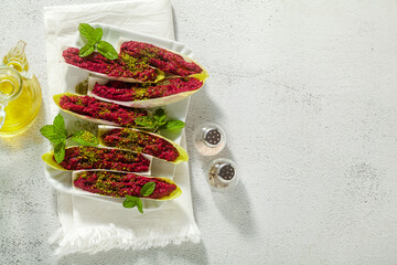 Wall Mural - dip of boiled beets and pistachios in leaves of Belgian Endive with mint. healthy summer snack