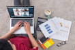 © weedezign - asian woman work from home with video conference online app collaboration with colleagues with business chart on laptop.live streaming meeting