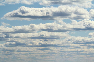 White fluffy clouds on a background of blue sky in summer. The concept of weather and climate.