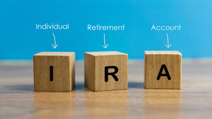 IRA individual retirement account word on wood cube block with blue background