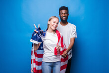 African Man And Caucasian Woman Covered With American Flag Isolated On Blue Background. Unity Of American People.