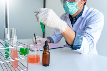 scientists researching in laboratory in white lab coat, gloves analysing, looking at test tubes sample, biotechnology concept