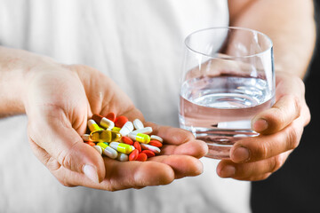 Wall Mural - Hand holding on open palm with pill tablets medicine for healing. Man takes medicines with glass of water