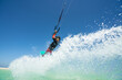 © ohrim - kiter does a difficult trick on a background of transparent water and blue sky