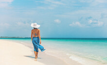 Caribbean Beach Vacation Luxury Elegant Lady Walking In Blue Beach Wrap Sarong Skirt Relaxing On Idyllic Holiday White Sand Beach Stroll.